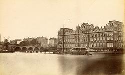 Molen Zoekplaatje 26 (Amsterdam), Op de foto is het Amstelhotel te zien, gebouwd 1863, links molen De Eendracht gesloopt 1876. Die foto is dus goed te dateren. Misschien dat we daarmee de datum van deze afbeelding kunnen achterhalen. | Database Nederlandse molens