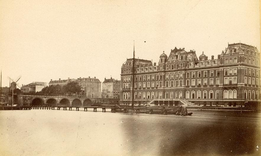 Molen Zoekplaatje 26 (Amsterdam), Op de foto is het Amstelhotel te zien, gebouwd 1863, links molen De Eendracht gesloopt 1876. Die foto is dus goed te dateren. Misschien dat we daarmee de datum van deze afbeelding kunnen achterhalen. | Database Nederlandse molens