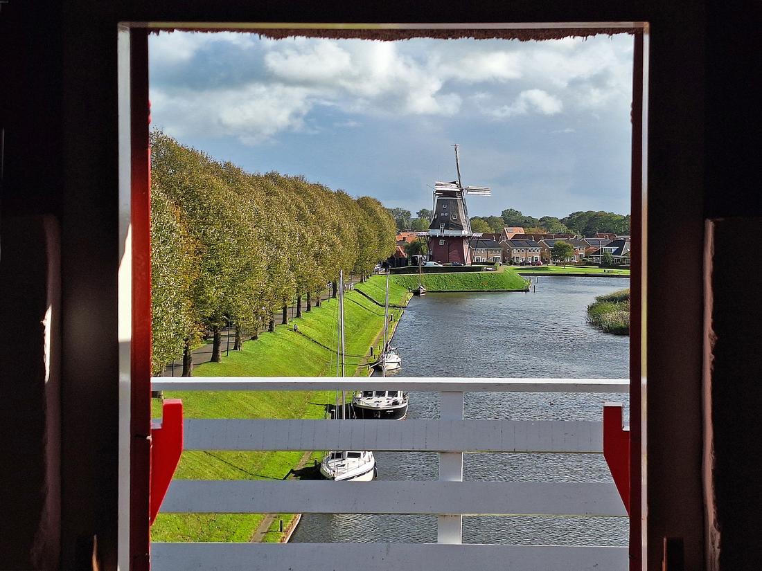 2, Molen 03246 De Hoop (Dokkum), Jay Verkerk (10-10-2026)'De Hoop' gezien door de stellingdeuren van buurmolen de 'Zeldenrust'. | Database Nederlandse molens