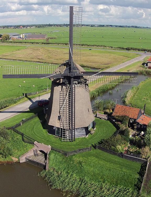 7, Molen 00122 Ondermolen O (Ursem), Zo te zien is er werk aan de onderste wiek, want het zeil is om de achterzoom geslagen.  Dronefoto: René Pronk (31-8-2014). | Database Nederlandse molens media-bestand