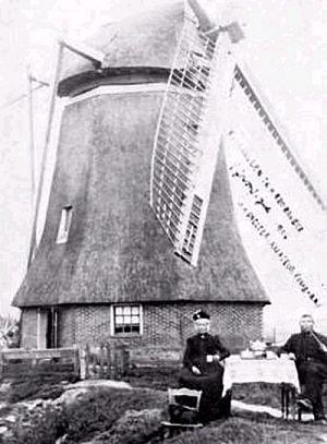 1, Molen 06424 b Nijverheidspolder (Wedderveer), Foto J.H. Snelter, amateur-fotograaf, opname 1 juli 1904. 
Het molenaarsechtpaar zit in hun beste kleren om te worden vereeuwigd! 
De afbeelding van deze ansichtkaart is ook te vinden in "Molens in Groningen" in oude ansichten op blz 71.  | Database Nederlandse molens media-bestand
