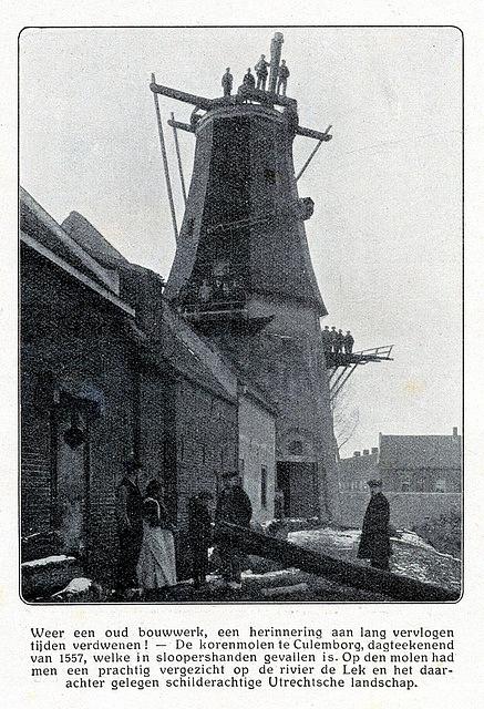 2, Molen 02472 h De Koornvriend (Culemborg), Foto uit krant 1917 (coll. V. Mepschen)
Wanneer je de foto goed bekijkt, zie je de ijzeren as halverwege het achtkant hangen, op de stukjes overgebleven stelling poseren heel wat mannen, met het gevaarte zo half boven hen. | Database Nederlandse molens media-bestand